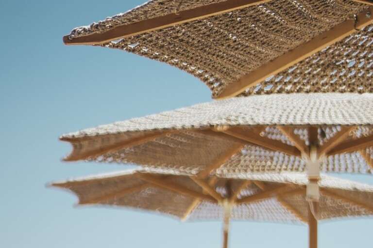 selective-vertical-shot-white-loungers-parasols-by-beach.9dcf7f