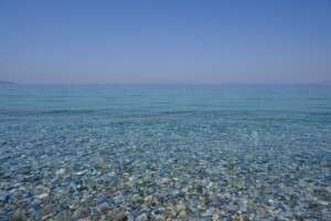 tranquil-pebble-beach-with-clear-blue-waters-under-a-bright--33407317