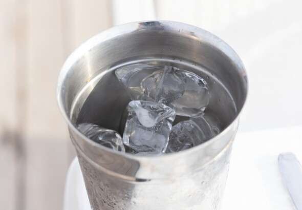 close-up-of-a-stainless-steel-cup-filled-with-ice-cubes-and--9036537