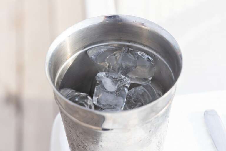 close-up-of-a-stainless-steel-cup-filled-with-ice-cubes-and--9036537