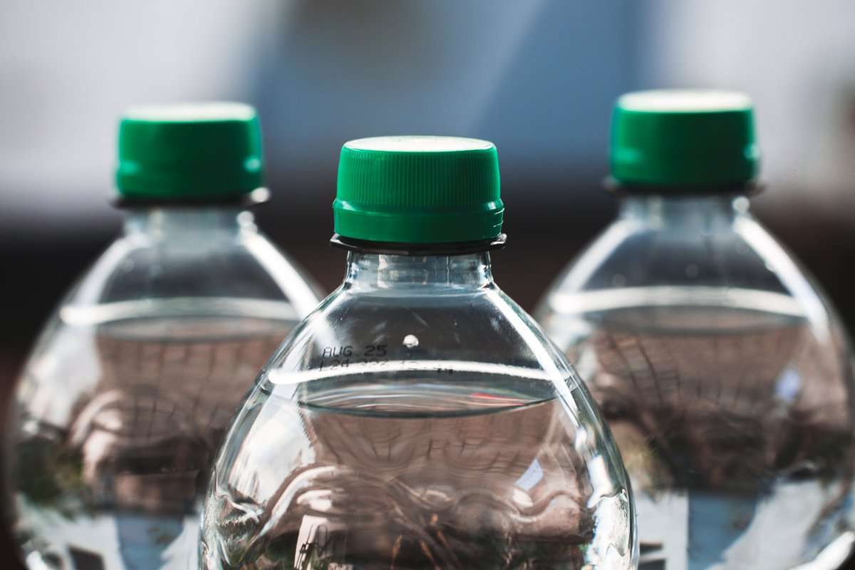 focused-view-of-three-clear-plastic-bottles-with-green-caps--31699476