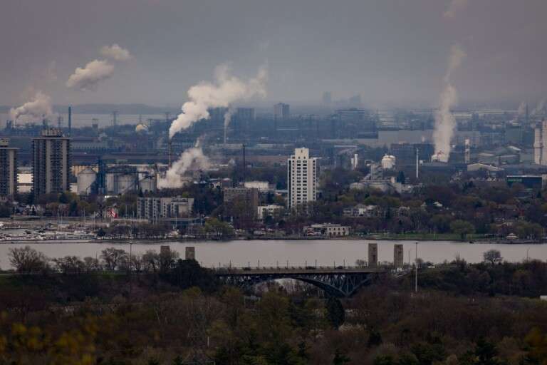urban-landscape-showing-factories-with-smoke-and-a-bridge-ov-35716659