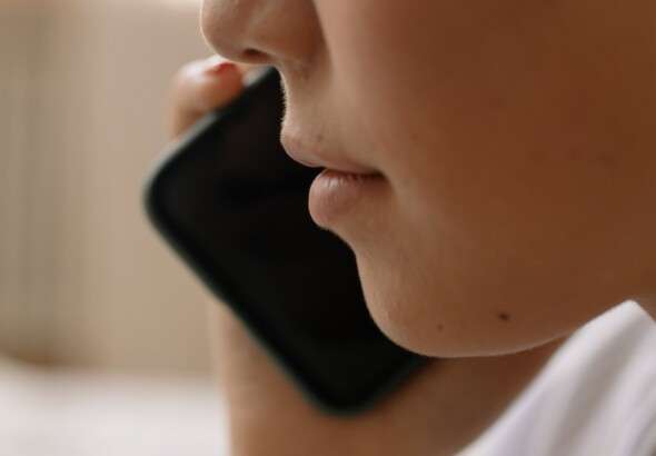 a-close-up-of-someone-talking-on-a-smartphone-focusing-on-th-6964143