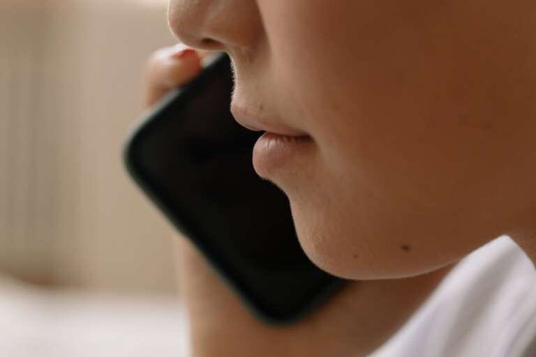 a-close-up-of-someone-talking-on-a-smartphone-focusing-on-th-6964143
