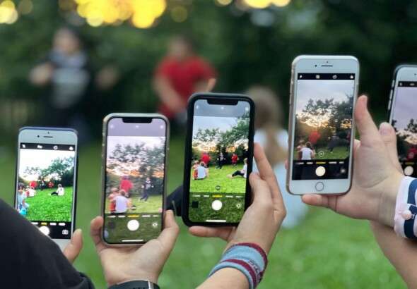 a-group-of-people-using-smartphones-to-photograph-an-outdoor-12860628