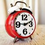 close-up-of-vintage-red-alarm-clock-on-rustic-wood-surface-i-280254