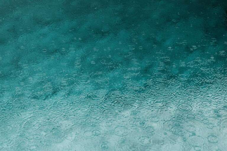 serene-teal-water-surface-with-ripples-and-raindrops-perfect-3394939